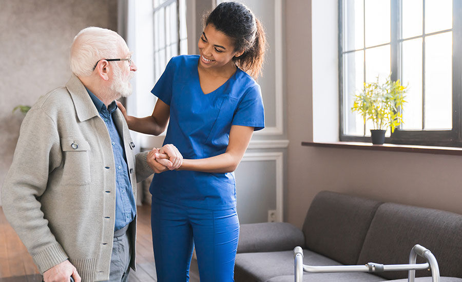 An elderly man being assisted by a caregiver