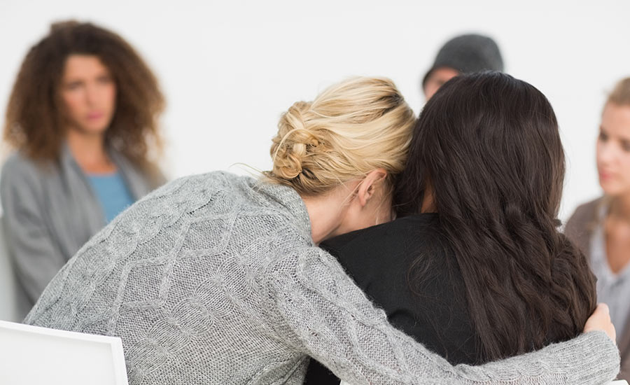 A caregiver hugging another individual