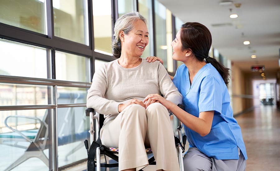 A caregiver smiling at a patient with dementia