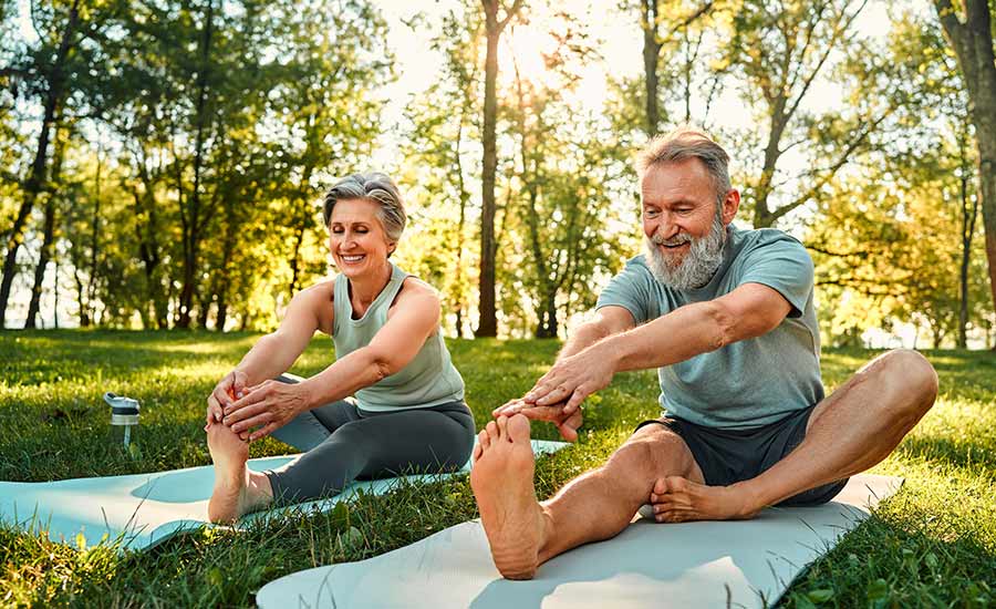 A senior couple stretching outside​