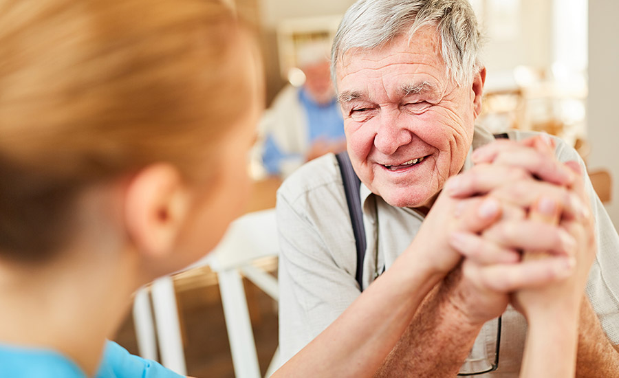 A caregiver laughing with a dementia patient