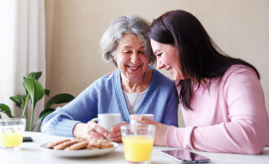 An elderly patient and her daughter smiling
