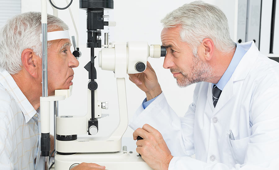A doctor evaluating a senior man's eyes