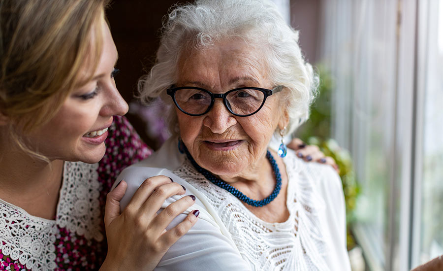 A family caregiver smiling at her senior loved one