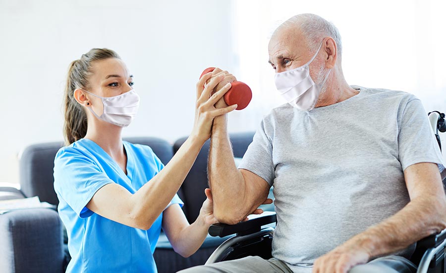 A nurse helping an elderly man exercise