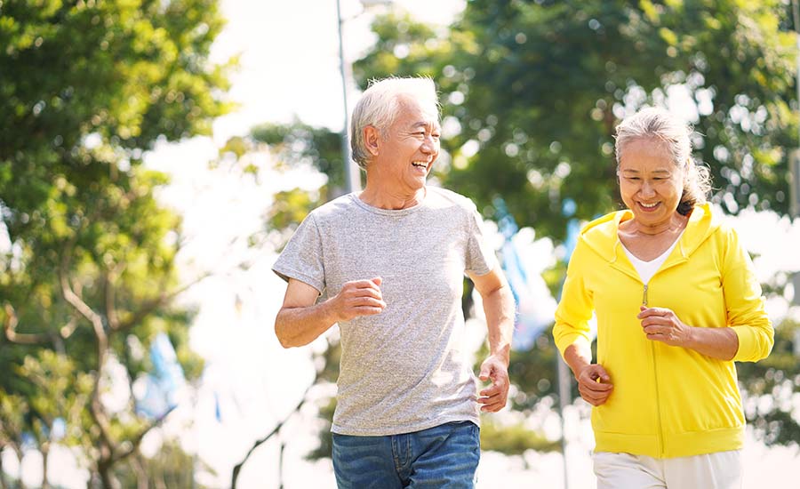 An elderly couple running in the park