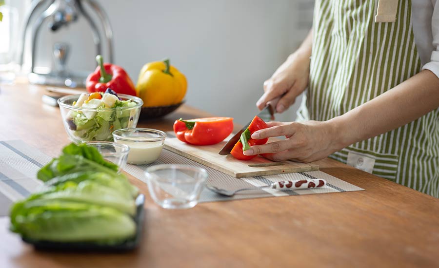 An elderly individual chopping vegetables