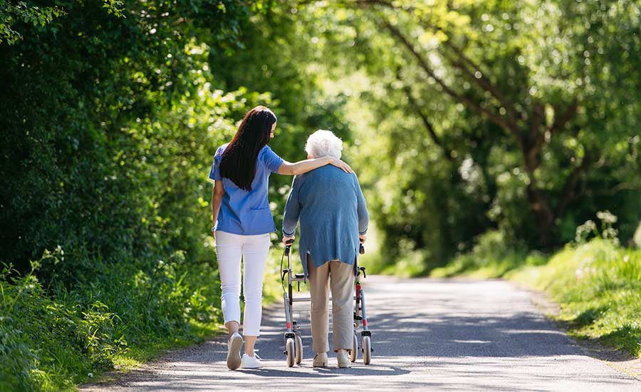 A caregiver accompanying an elderly patient on a walk, nurturing their dignity and well-being