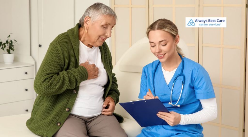 A senior woman and a caregiver in a medical setting, discussing care plans and health management. The caregiver is taking notes while the senior looks on, illustrating the professional support provided in home care.